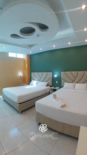 2 camas en una habitación de hotel con 2 camas en Hotel Spring, en Huánuco
