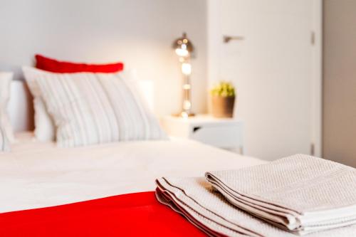 a white bed with two towels on top of it at Bo&Co Apartments in Sitges