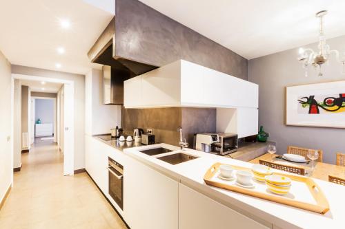 a kitchen with white cabinets and a counter top at Bo&Co Apartments in Sitges