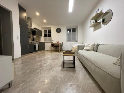 a living room with a couch and a kitchen at Kleine moderne 3-Bett Wohnung/Apartment in Garsten