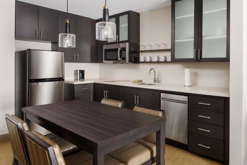 a kitchen with a wooden table and stainless steel appliances at Residence Inn by Marriott New Haven Hamden in Hamden