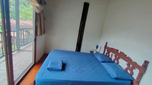 a bedroom with a blue bed and a balcony at Quinta Felicidad in Pedro Vicente Maldonado