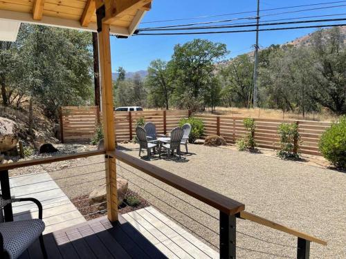a porch with chairs and a table and a fence at Soleil Luna 2 miles from Sequoia Park Entrance in Three Rivers