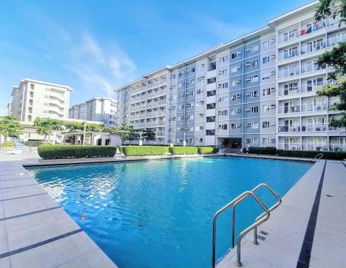 a large swimming pool in front of a building at Me N’ My Bed Staycation @ SMDC Trees Residences in Manila