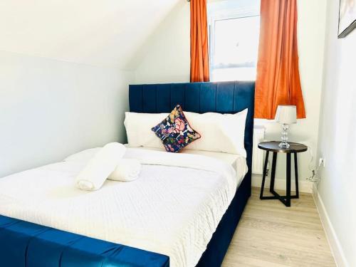 a blue and white bed in a room with a window at Cosy Dover Flats, Castle view in Kent