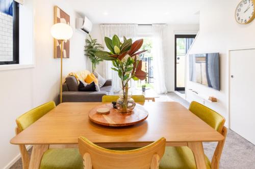a dining room and living room with a wooden table and chairs at Prime Location: Hagley, Riverside, Hospital in Christchurch