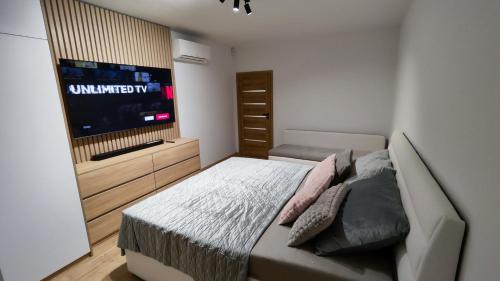 a bedroom with a bed and a flat screen tv at Nový Exkluzívny 2 izbový apartmán Rajpark Residence Rajecké Teplice in Rajecké Teplice