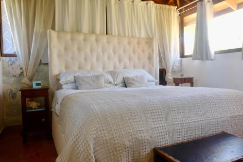 a bedroom with a large white bed with pillows at V&V Beach House in Punta Cana
