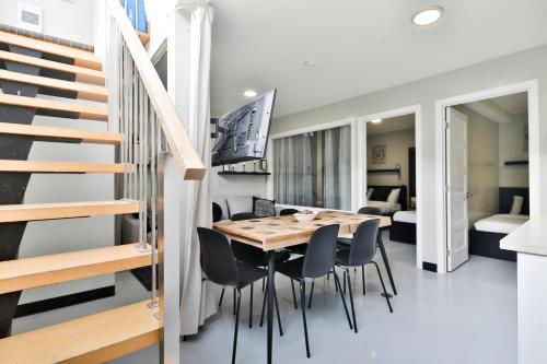a dining room with a table and chairs and a staircase at Parc Avenue Lofts in Montréal