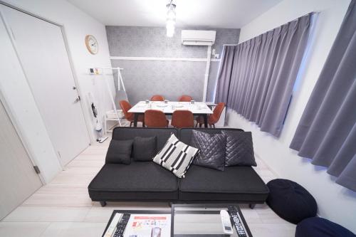 東京的住宿－Kitaikebukuro Kodate - Vacation STAY 8854，客厅配有黑色沙发和桌子