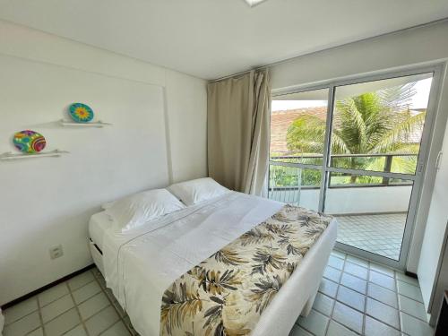 a bedroom with a bed and a balcony at Ancorar Flat Resort in Porto De Galinhas