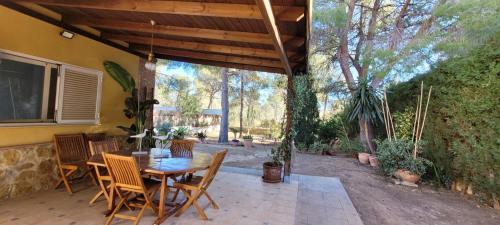 een patio met een houten tafel en stoelen bij Luxe Vista Retreat in Serra