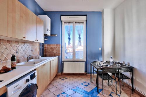 una cucina con pareti blu e tavolo e sedie di Grand T2 entier-5p-2 balcons - Appartement central a Saint-Fons
