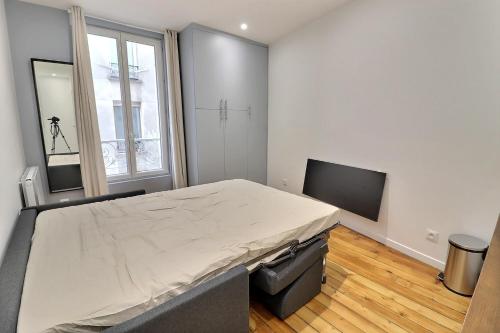 um quarto com uma cama grande e uma televisão de ecrã plano em Appartement 2 personnes Paris em Paris