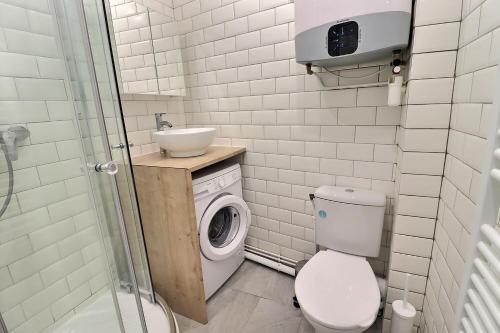 uma casa de banho com um WC, um lavatório e uma máquina de lavar roupa em Appartement 2 personnes Paris em Paris