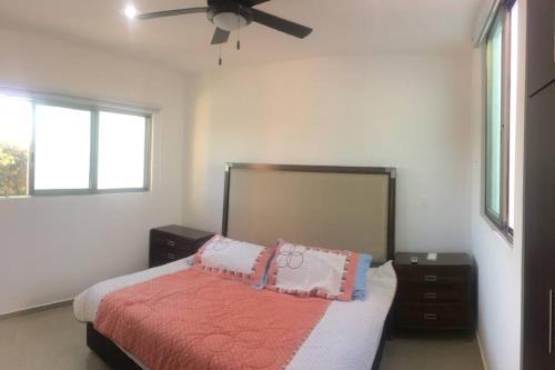a bedroom with a bed and a ceiling fan at Residencia con ALBERCA y JARDÍN privado in Cholul