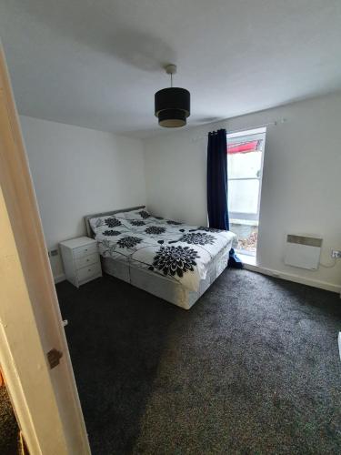 Quiet 2 bedroom flat in Darlington with free parking, wi-fi and more في دارلينغتون: غرفة نوم بسرير ونافذة