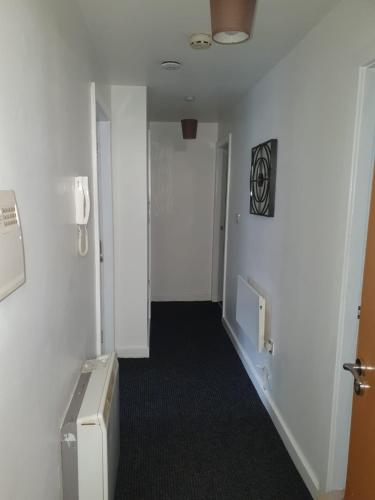 ein leerer Flur mit einer Tür und ein Zimmer mit einem TV in der Unterkunft Quiet 2 bedroom flat in Darlington with free parking, wi-fi and more in Darlington
