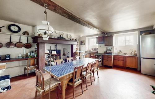 une cuisine avec une table, des chaises et un réfrigérateur dans l'établissement 8 Bedroom Cozy Home In Saint-Vigor, à Saint-Vigor