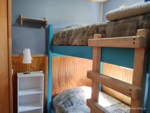 a bedroom with two bunk beds and a lamp at Cabaña Precordillera Cunco in Cunco