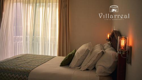 Hotel Villarreal, Restaurante y Bar Ticul في Ticul: غرفة نوم بسرير ومخدات بيضاء ونافذة