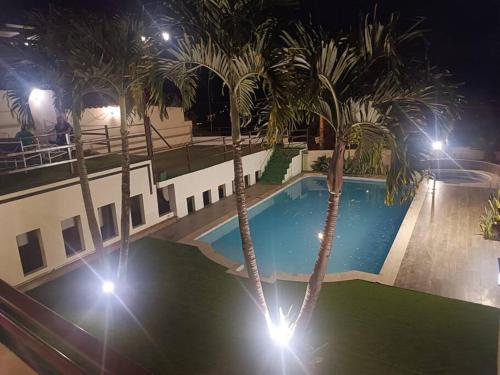 a swimming pool at night with palm trees and lights at Casa de campo Country house in Yunguilla, Cuenca, Ecuador in Cuenca