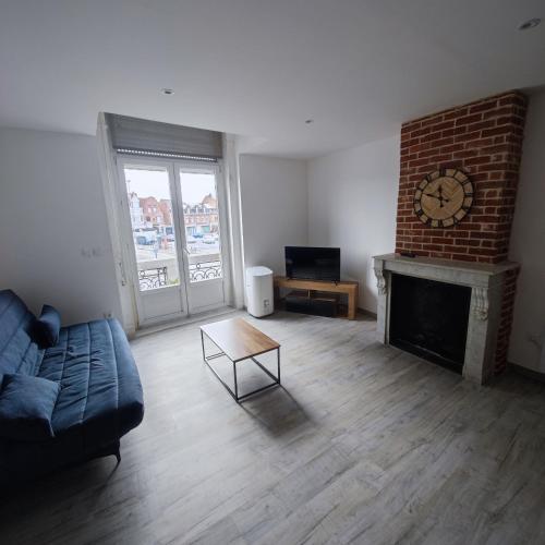 un salon avec un canapé et une cheminée dans l'établissement Appartement centre Merville, à Merville