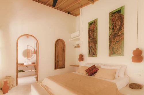 a white bedroom with a bed and a mirror at Yama Balian in Tabanan