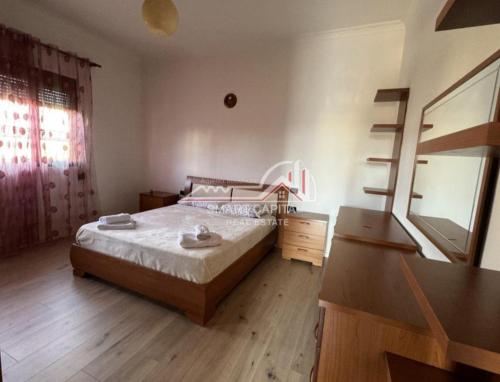 1 dormitorio con cama, tocador y espejo en house for rent vlore en Vlorë