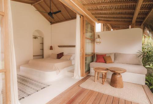 a living room with two beds and a table at Yama Balian in Tabanan