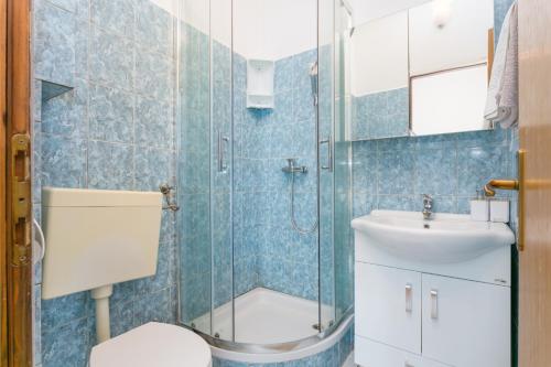 La salle de bains est pourvue d'une douche, de toilettes et d'un lavabo. dans l'établissement Apartments with a parking space Marina, Trogir - 1093, à Marina