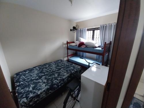 a small room with two bunk beds and a refrigerator at Casa da ana in Penha