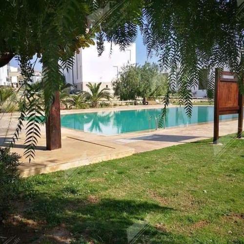 een leeg zwembad in een park met een boom bij Studio Taghazout Bay avec grand jardin in Taghazout