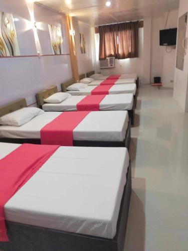 Eine Reihe von Betten befindet sich in einem Zimmer in der Unterkunft Auzone Inn Budget Hometel in Locsin