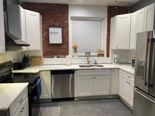 a kitchen with white cabinets and a sink at Entire 2 Bed apartment in Allentown
