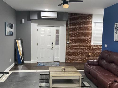 a living room with a brown couch and a door at Entire 2 Bed apartment in Allentown