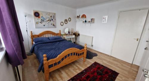 een slaapkamer met een houten bed met blauwe kussens bij Spacious flat near central in Londen