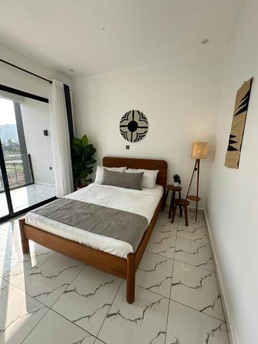 a bedroom with a bed and a clock on the wall at Coalescence Hotel Rwanda in Kigali