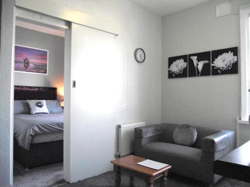 a living room with a couch and a bed at Seahawk Holiday Apartments in Cleveleys