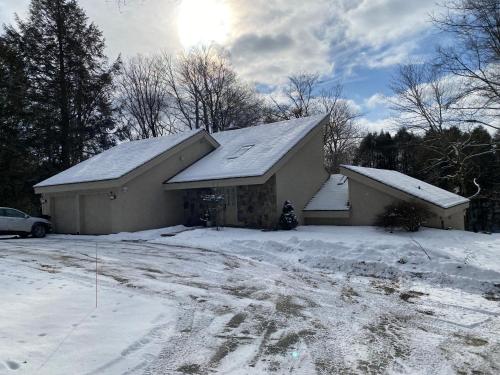 a house with snow on the roof of it at Catskills Pond Getaway in Liberty