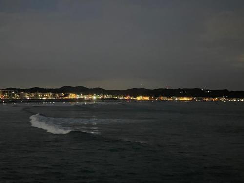 a beach at night with a city in the background at Children's cafe B&B Kimie in Kamakura