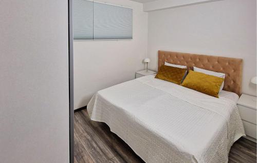 - une chambre avec un lit doté de draps blancs et d'oreillers jaunes dans l'établissement 2 Bedroom Gorgeous Apartment In Bors, à Borås