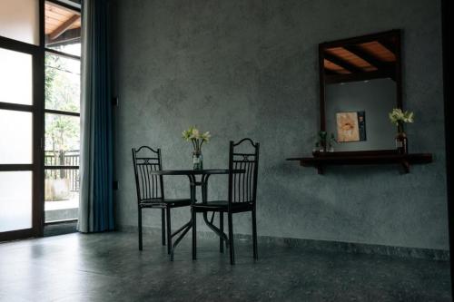 mesa de comedor con 2 sillas y espejo en Amanzi Residence, en Kandy