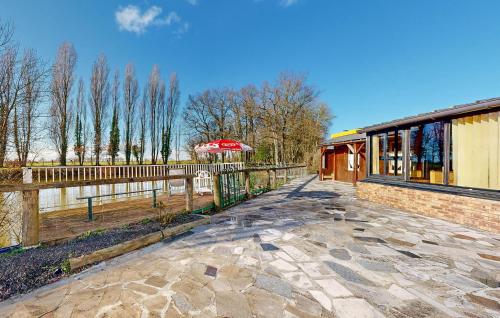 a building with a fence next to a walkway at Stunning Home In La Bazouge-De-Chemeré in La Cropte