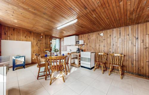 a kitchen with wooden walls and a table and chairs at Stunning Home In La Bazouge-De-Chemeré in La Cropte