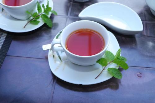 a cup of tea on a plate with a plant at Princess of Dickoya Homestay in Hatton