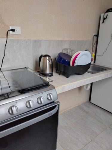 a kitchen counter with a stove and a pot and pans at casa jardines san francisco in Valladolid