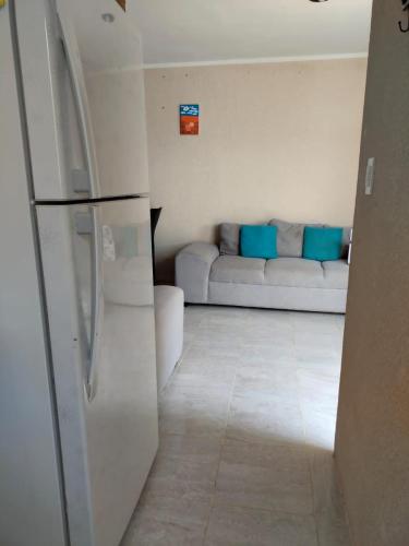 a living room with a couch and a refrigerator at casa jardines san francisco in Valladolid