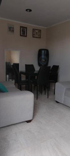 sala de estar con sofá, mesa y sillas en casa jardines san francisco, en Valladolid