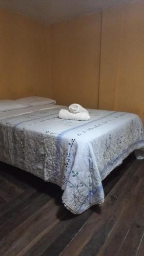 a bed with two towels on top of it at Casa de Albert in Mindo